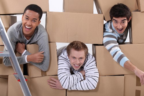 Moving team handling boxes and furniture during a house removal